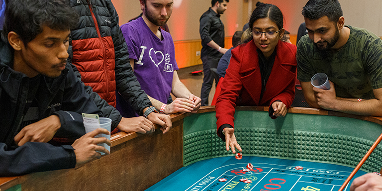 Students rolling dice at a casino event.